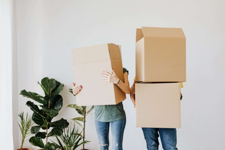 Young couple hiding behind boxes